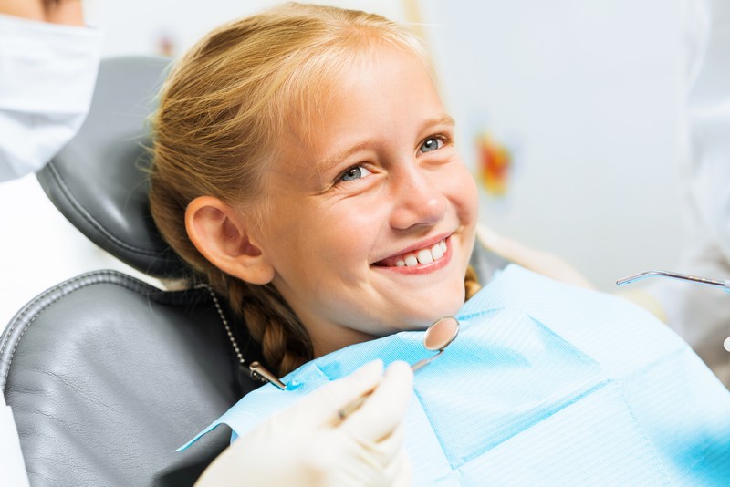 Child smiling with healthy teeth after fluoride treatment